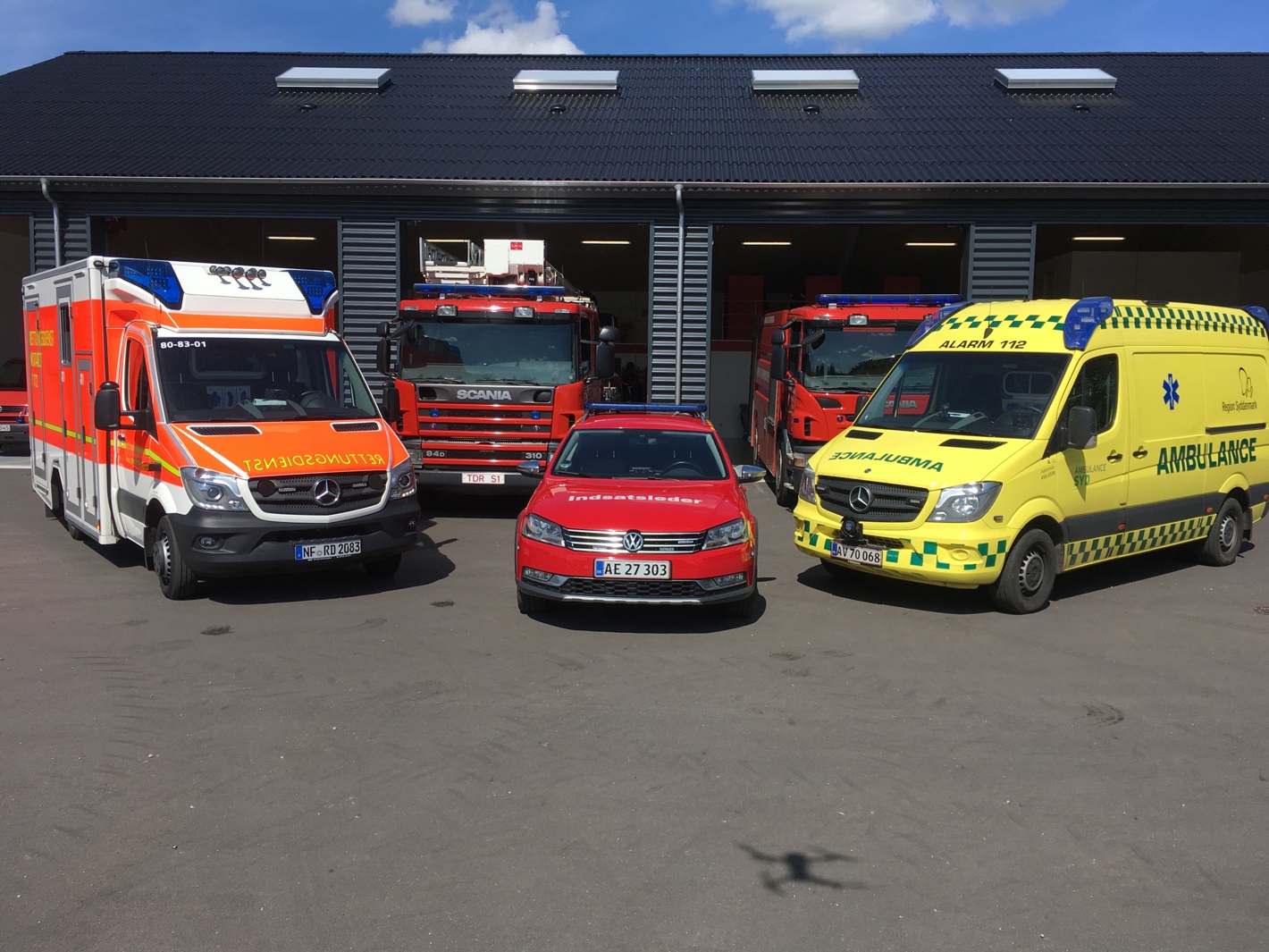 Brandbiler og ambulancer foran brandstation