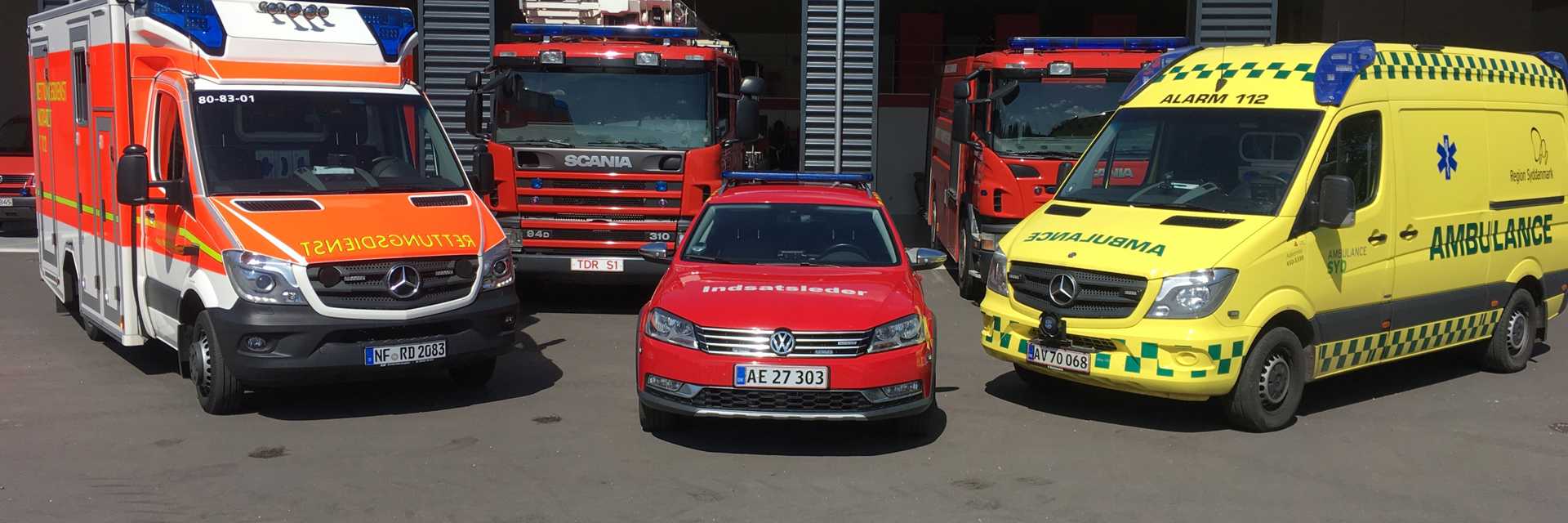 Brandbiler og ambulancer foran brandstation